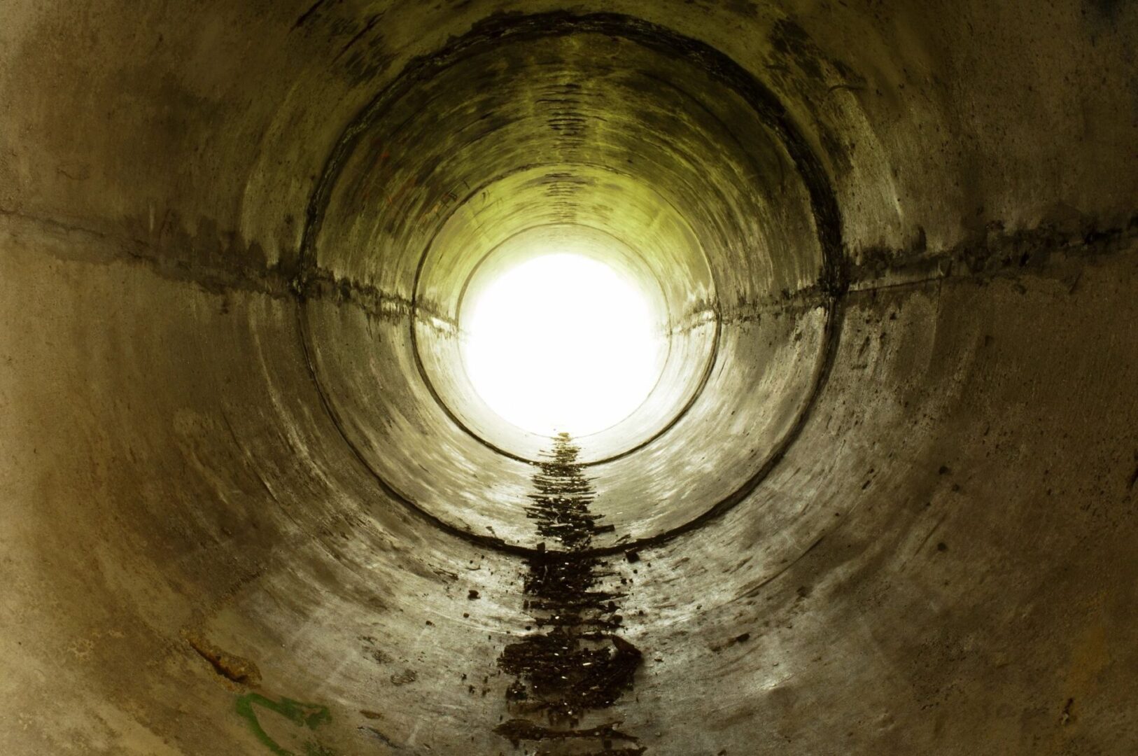 A light shining in the middle of an underground tunnel.